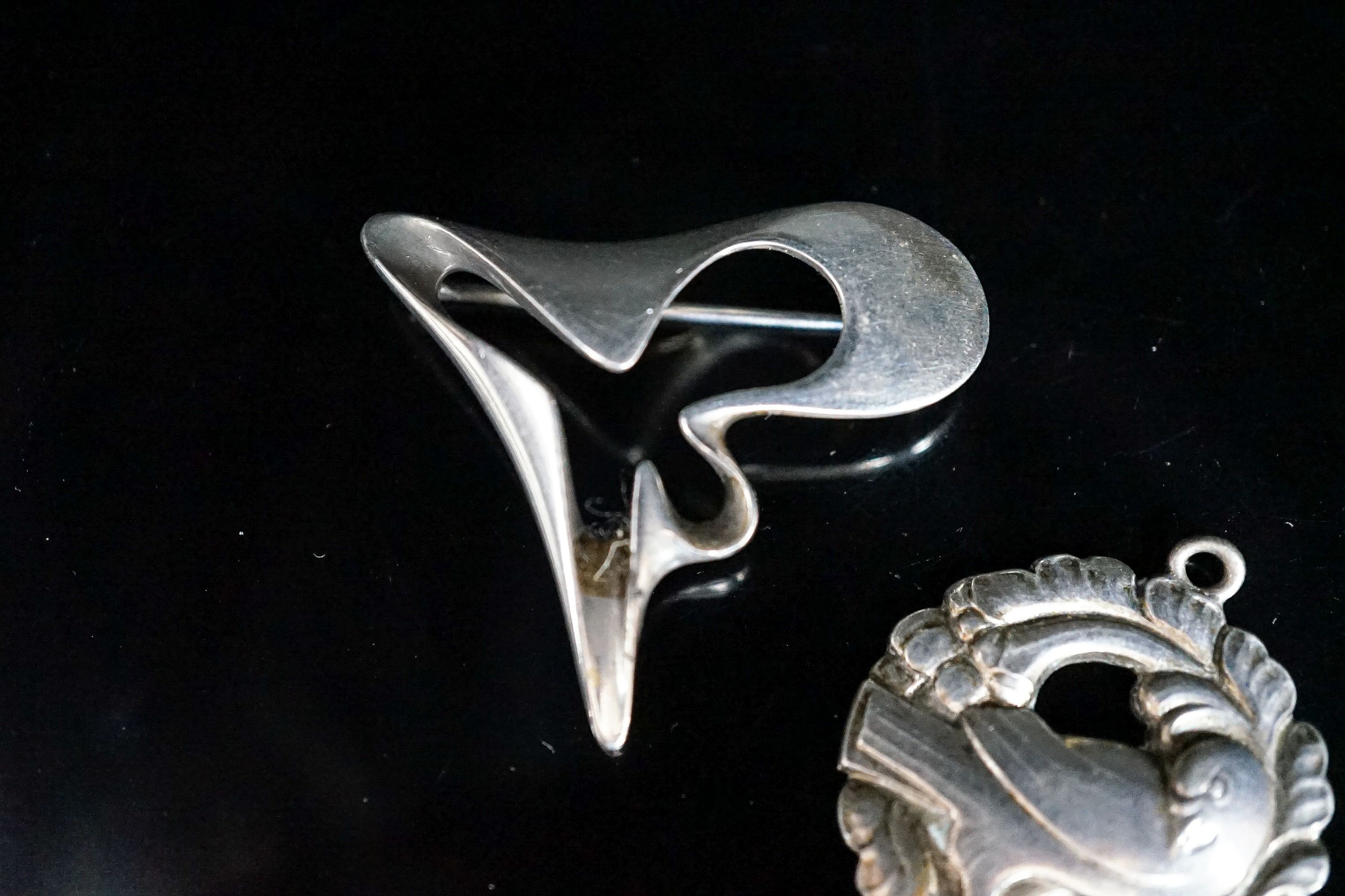 A Georg Jensen sterling abstract brooch, no. 324, 41mm and a Georg Jensen sterling pendant (converted brooch), no. 134.